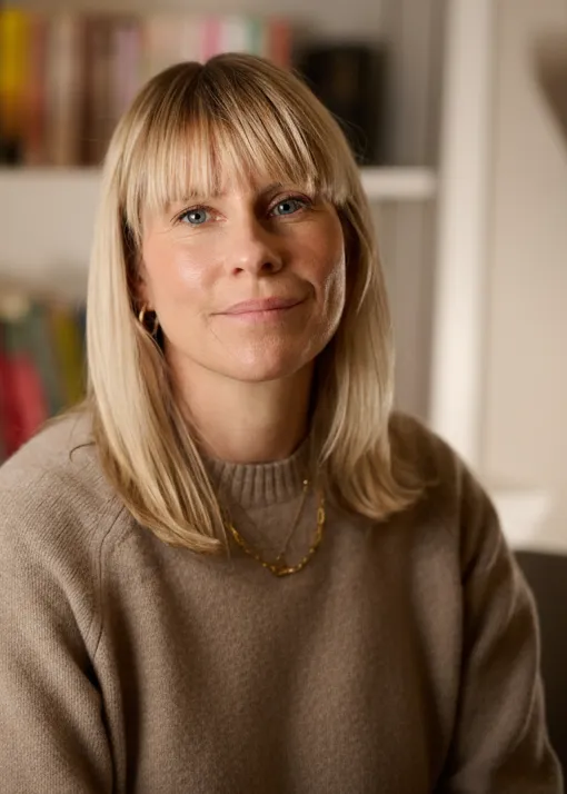 Alex Bickford, an integrative psychotherapist, photographed in front of a bookshelf